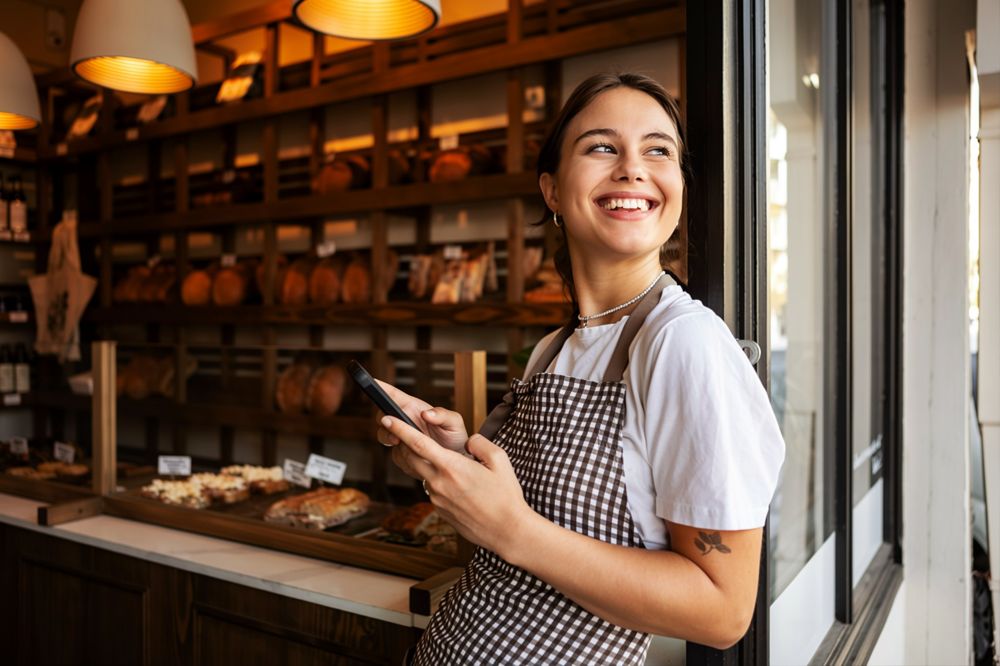 Dueña de una panadería revisando en el celular cuánto le dejó el día